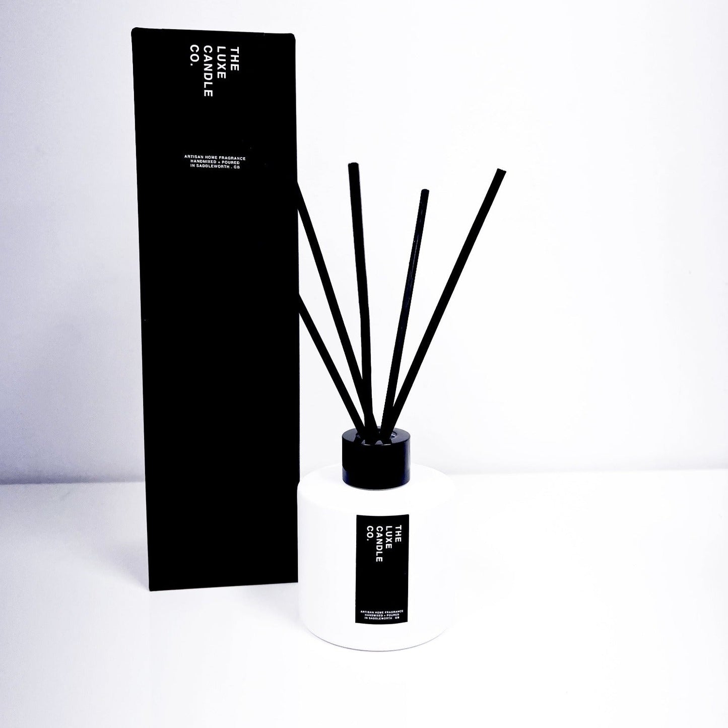 thailand reed diffuser - white and black diffuser with black reeds fragranced in lemongrass and thai ginger
